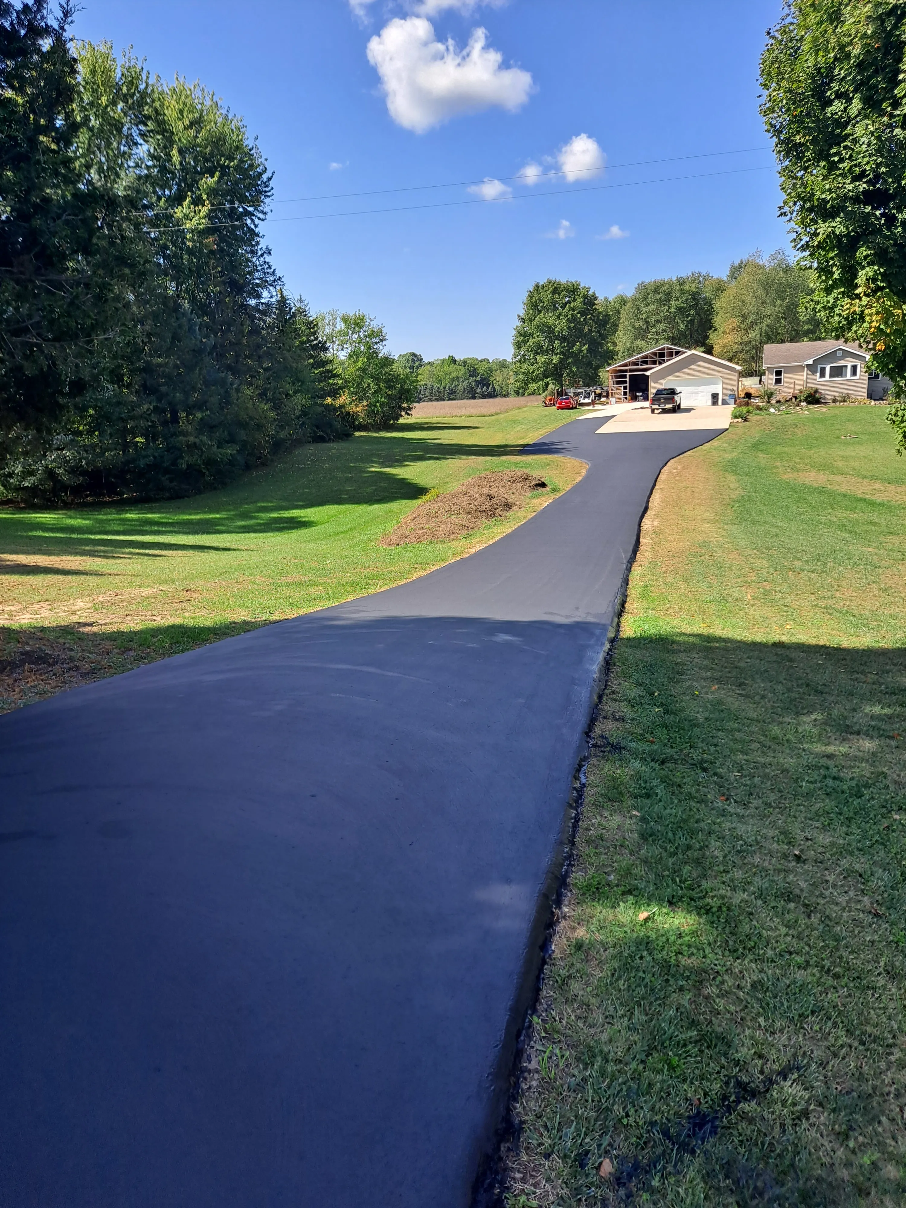 Freshly broom-sealed asphalt driveway with a rich black finish